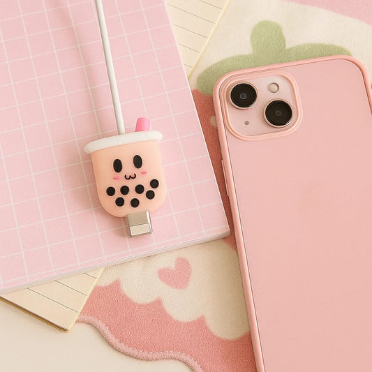 un protège câble tout mignon en forme de bubble tea rose avec une expression ultra kawaii.