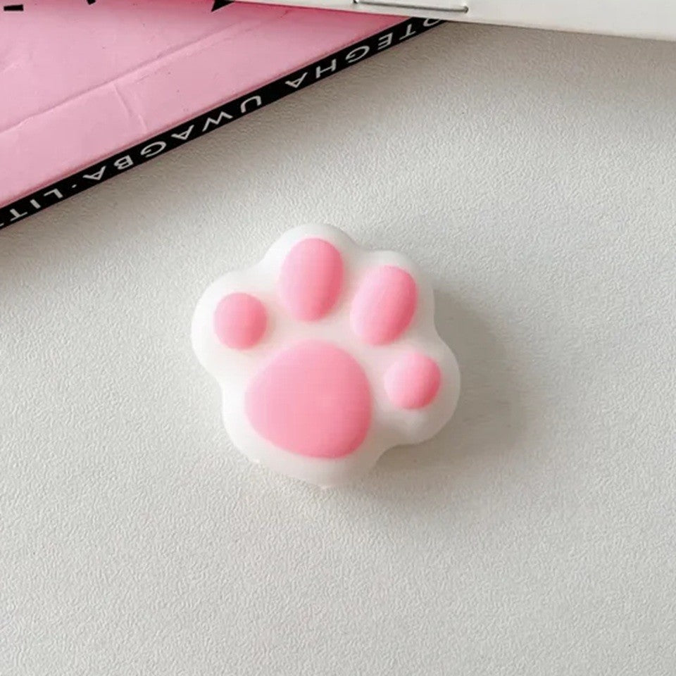 un protège câble tout mignon en forme de patte de chat rose et blanc. Pratique et utile, il protège vos câbles de l'usure et allonge leur durée de vie.