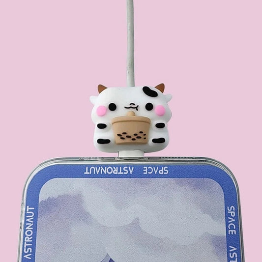 un protège-câble en forme de petite vache noire et blanche trop rigolote avec son bubble tea. Il protège vos câbles de l'usure et allonge leur durée de vie.