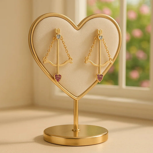 une paire de boucles d'oreilles en forme d'arc de cupidon avec sa flèche à la pointe strass roses