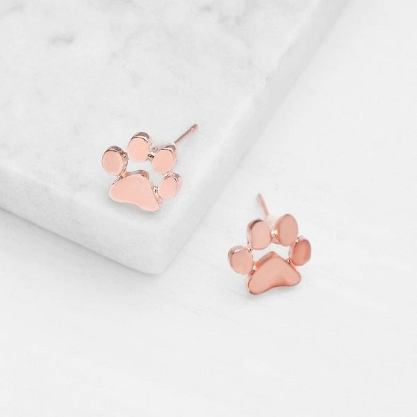 une paire de boucles d'oreilles en forme de pattes d'animaux en coloris rose gold