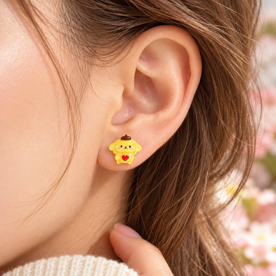 Puce d’oreille Pompompurin jaune kawaii portée à l’oreille, petit bijou Sanrio discret avec cœur rouge, idéal pour un look mignon.