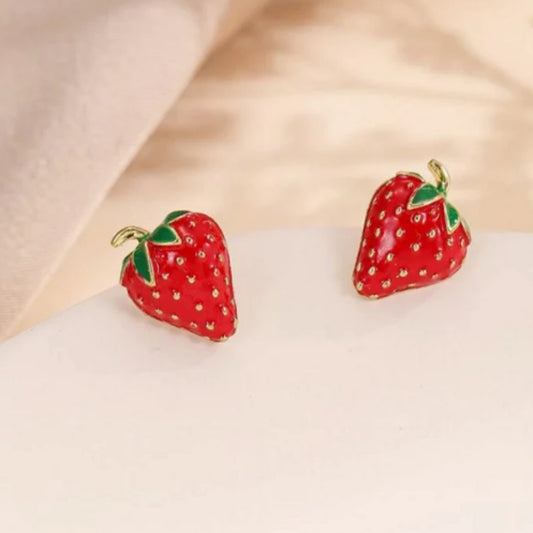 une paire de puces d'oreilles toutes mignonnes en forme de fraises bien rouges et de détails dorés