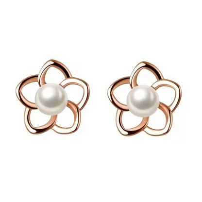 des puces d'oreilles en forme de petites fleurs dorées dont le coeur est une perle blanche. Le style est minimaliste et élégant.