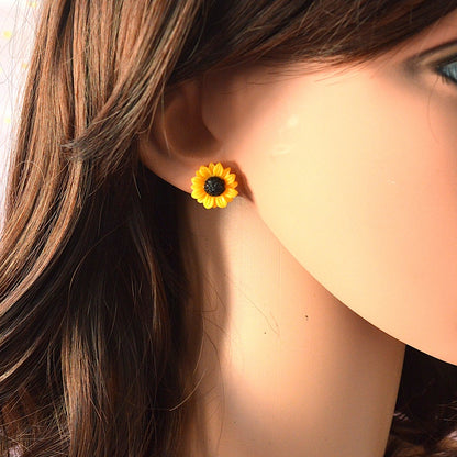 une paire de boucles d'oreilles en forme de tournesols jaunes hyper mignons et réalistes.