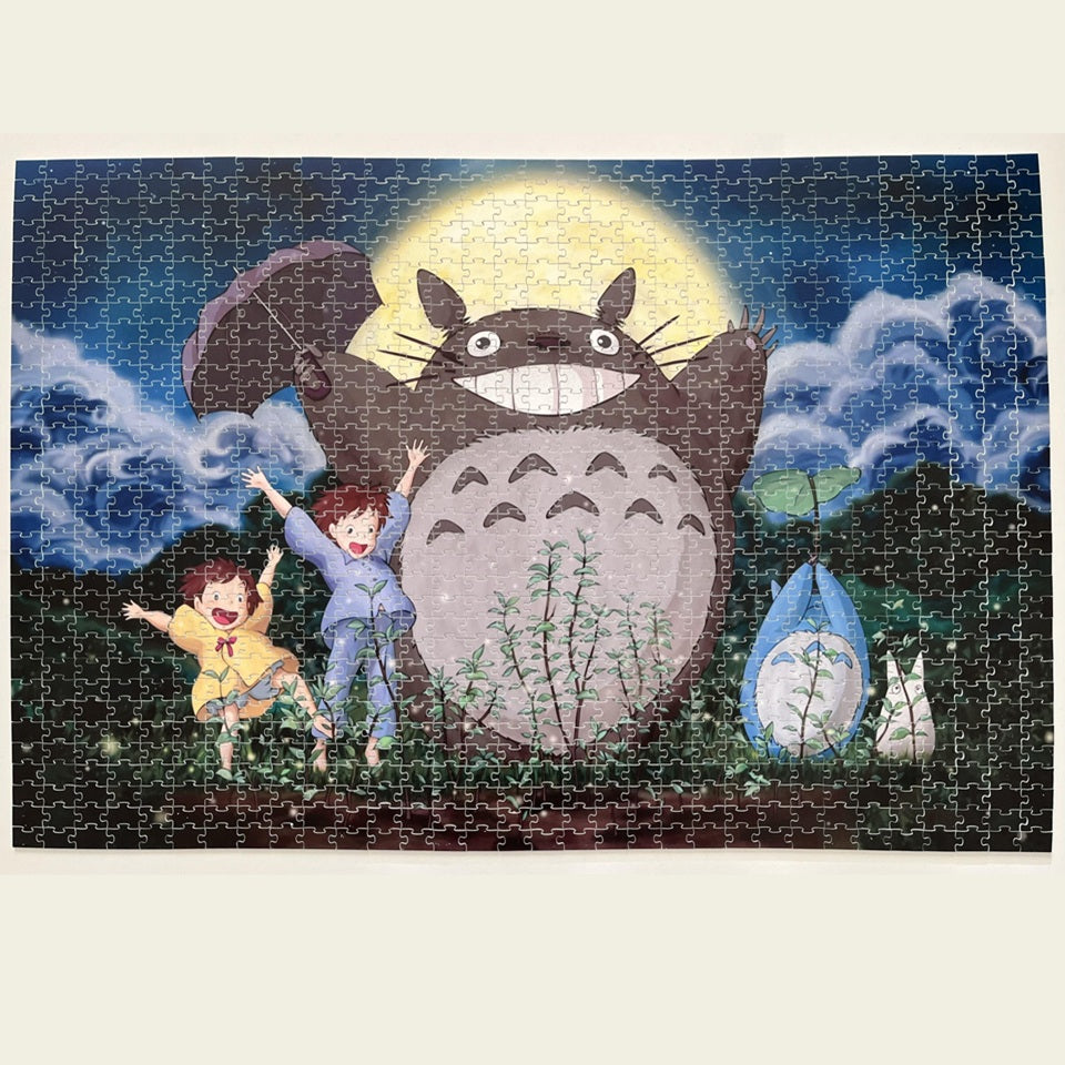 un puzzle composé de 1000 pièces représentant Totoro, Mei, Satsuki et les chibi Totoro dansant sous la lune pour invoquer la pluie afin que les arbres poussent.