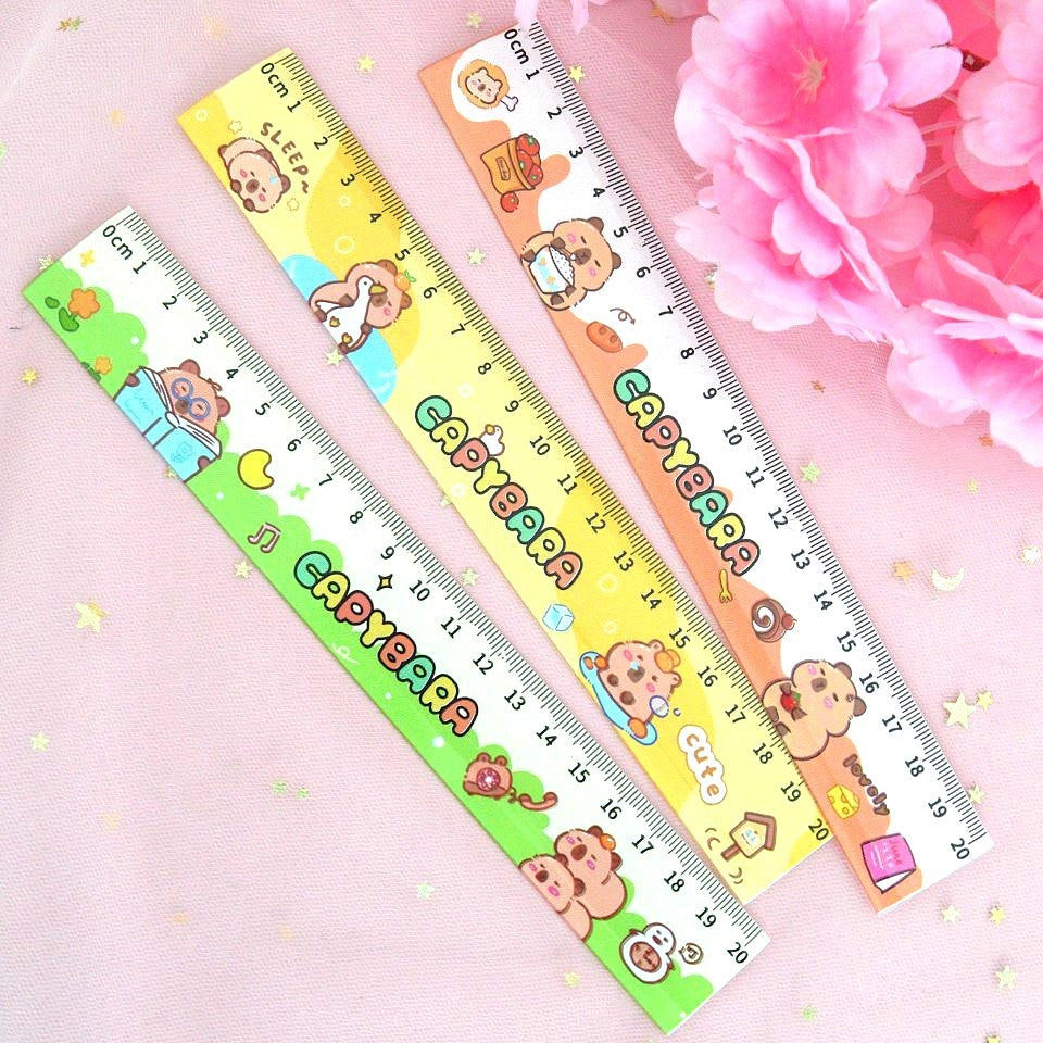 une jolie règle colorée de 20 cm avec de jolies illustrations de capybara dans des scènes et des expressions amusantes et rigolotes. 