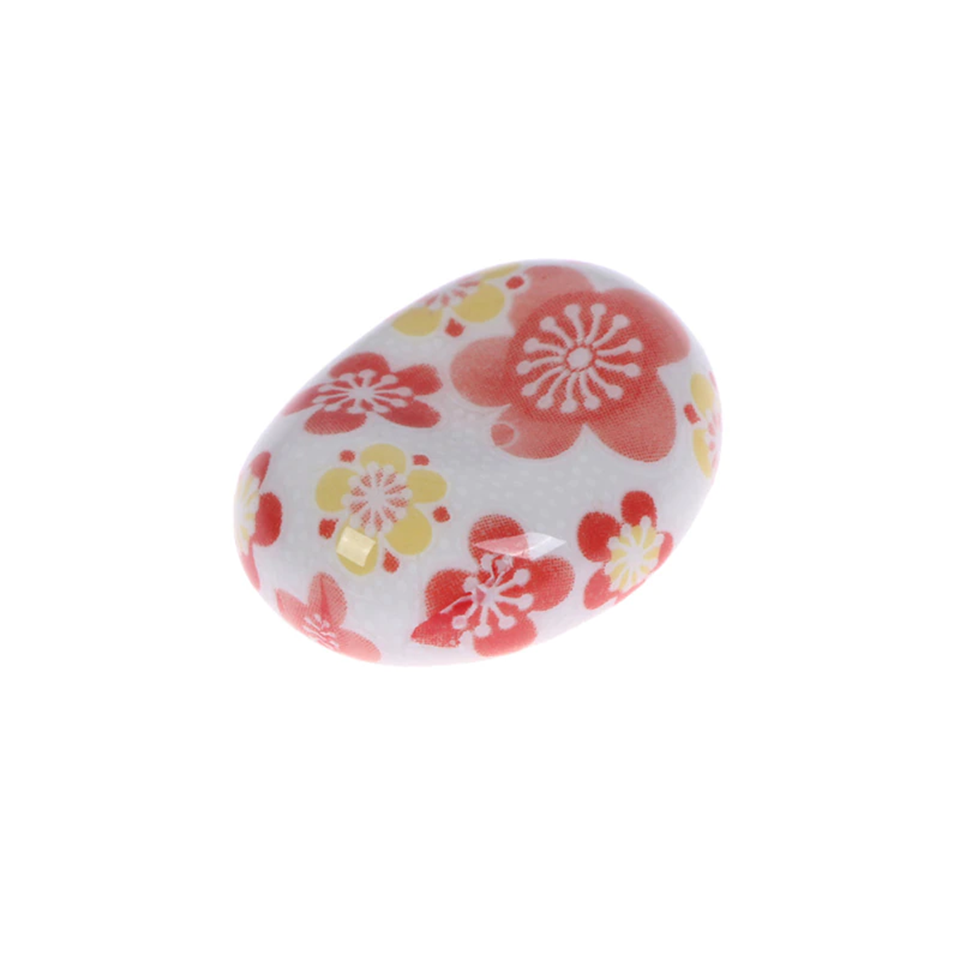 des repose baguettes en forme de galets aux motifs et aux couleurs de l'esthétique japonaise : formes géométriques et fleurs de sakura
