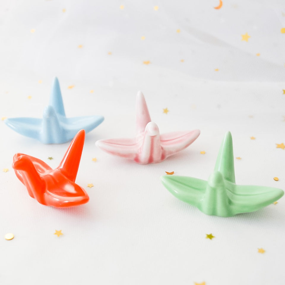 des repose baguettes en forme de grue japonaise colorée : rose, orange, bleu et vert. En céramique, elles sont résistantes et durables et ajoutent une touche authentique du Japon et d'élégance sur votre table.