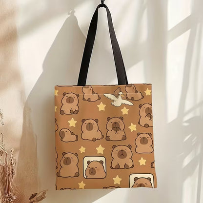 un sac fourre-tout marron au design de capybara et d'étoiles trop mignons. Il est suspendu à un mur dans une ambiance calme et zen.