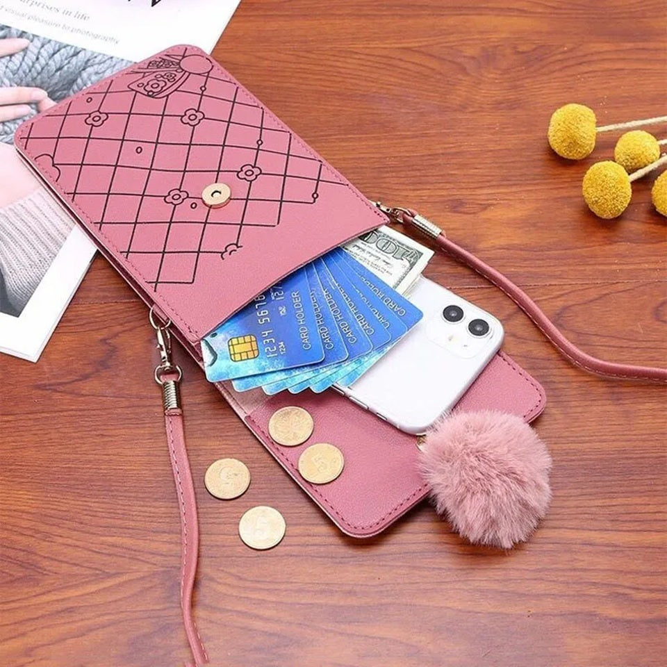 Intérieur d'une sacoche téléphone rose kawaii pour femme, posé sur un bureau e, chêne. Le sac est ouvert afin de montrer ses compartiments de rangement et son espace de stockage : des pièces de monnaie, des cartes et une smartphone y sont rangés.