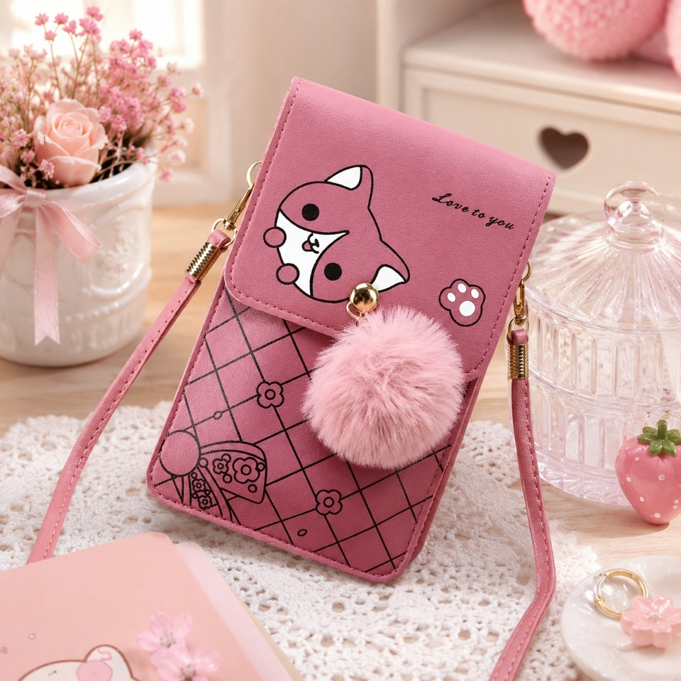 Sacoche téléphone rose kawaii avec motif chat, pompon en fausse fourrure et bandoulière, présentée dans un décor pastel mignon avec fleurs, accessoires décoratifs et lumière naturelle, idéale comme petit sac à bandoulière pour femme.