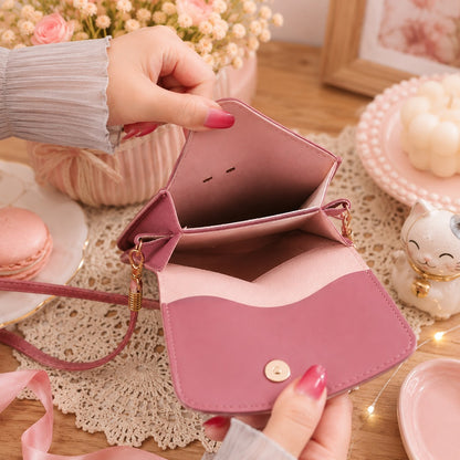 Intérieur d'une sacoche téléphone rose kawaii pour femme, présenté dans un décor pastel romantique. Le sac est ouvert et tenu en main afin de montrer ses compartiments de rangement et son espace de stockage, entouré d'accessoires décoratifs mignons, d'une bougie, de fleurs et d'une figurine de chat.