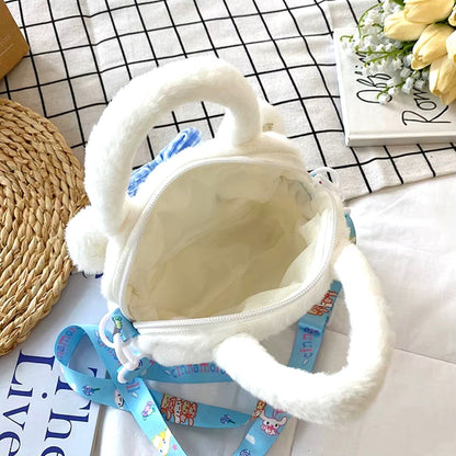 une petite sacoche toute douce et fluffy de Cinnamoroll. Elle est blanche, a une bandoulière bleue. On voit l'intérieur de la sacoche.