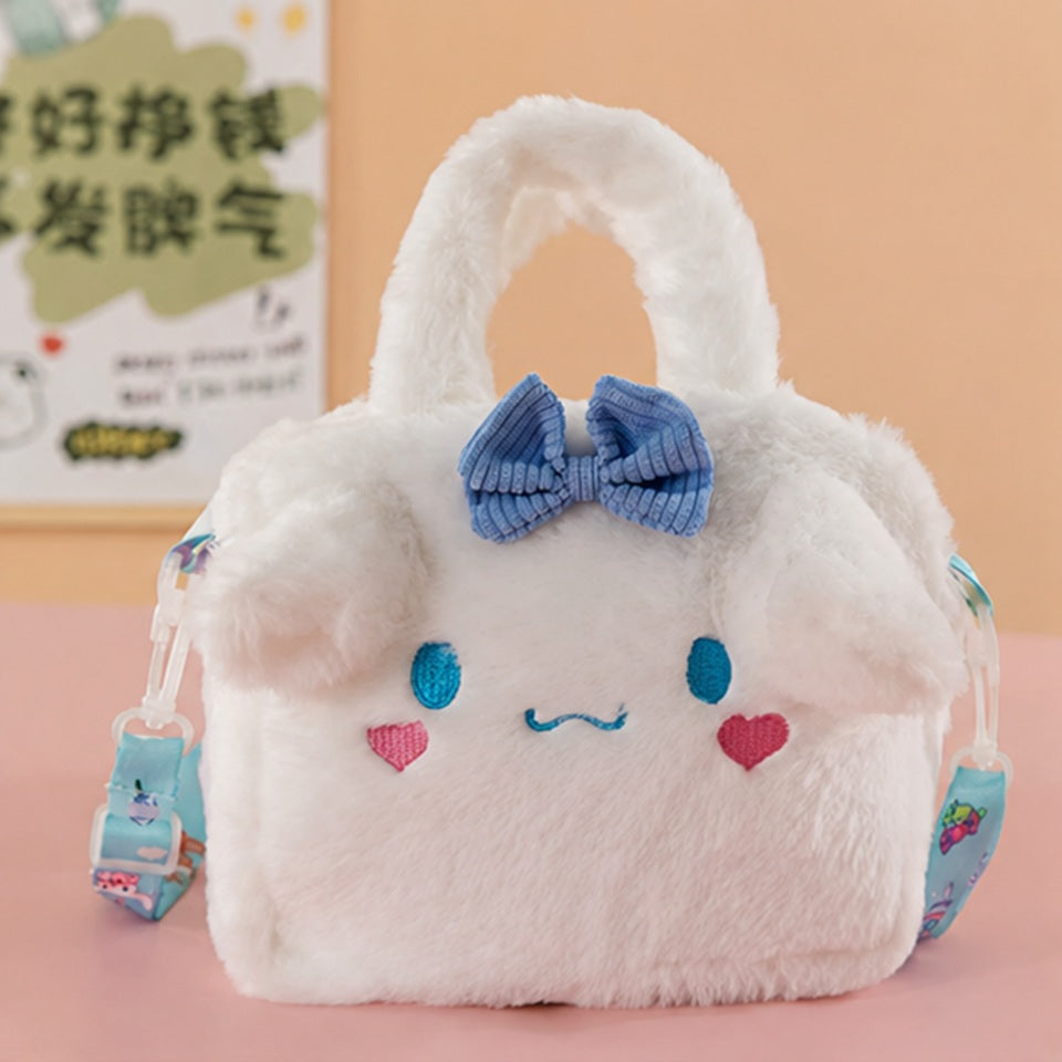 une petite sacoche toute douce et fluffy de Cinnamoroll. Elle est blanche et les yeux et des coeurs roses sont brodés dessus et arbore un joli noeud bleu. Elle a une expression kawaii et adorable.