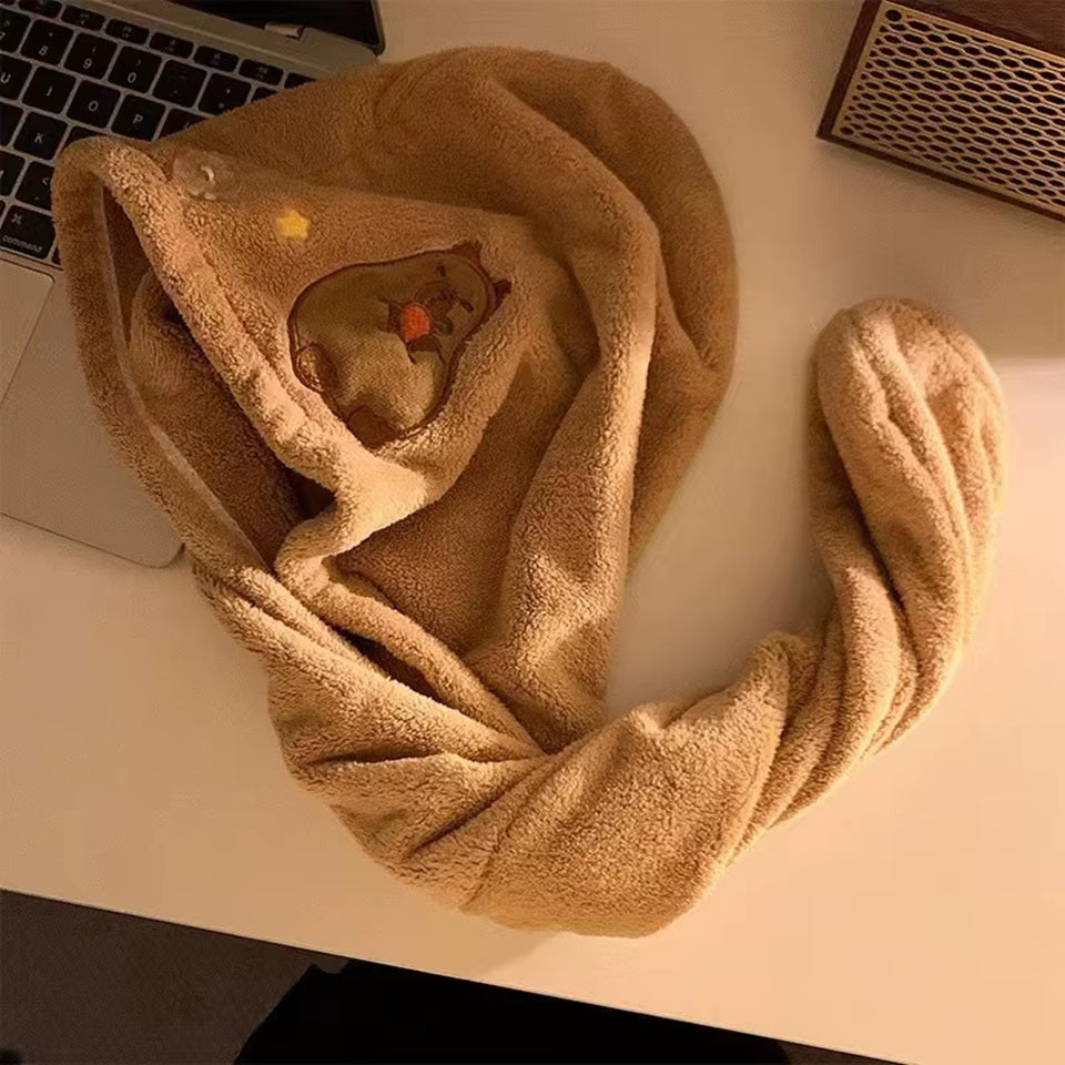 une serviette pour cheveux capybara toute mignonne. Avec son capybara brodé et son sourire charmeur, elle est utile et pratique pour maintenir et sécher les cheveux après la douche ou le bain.