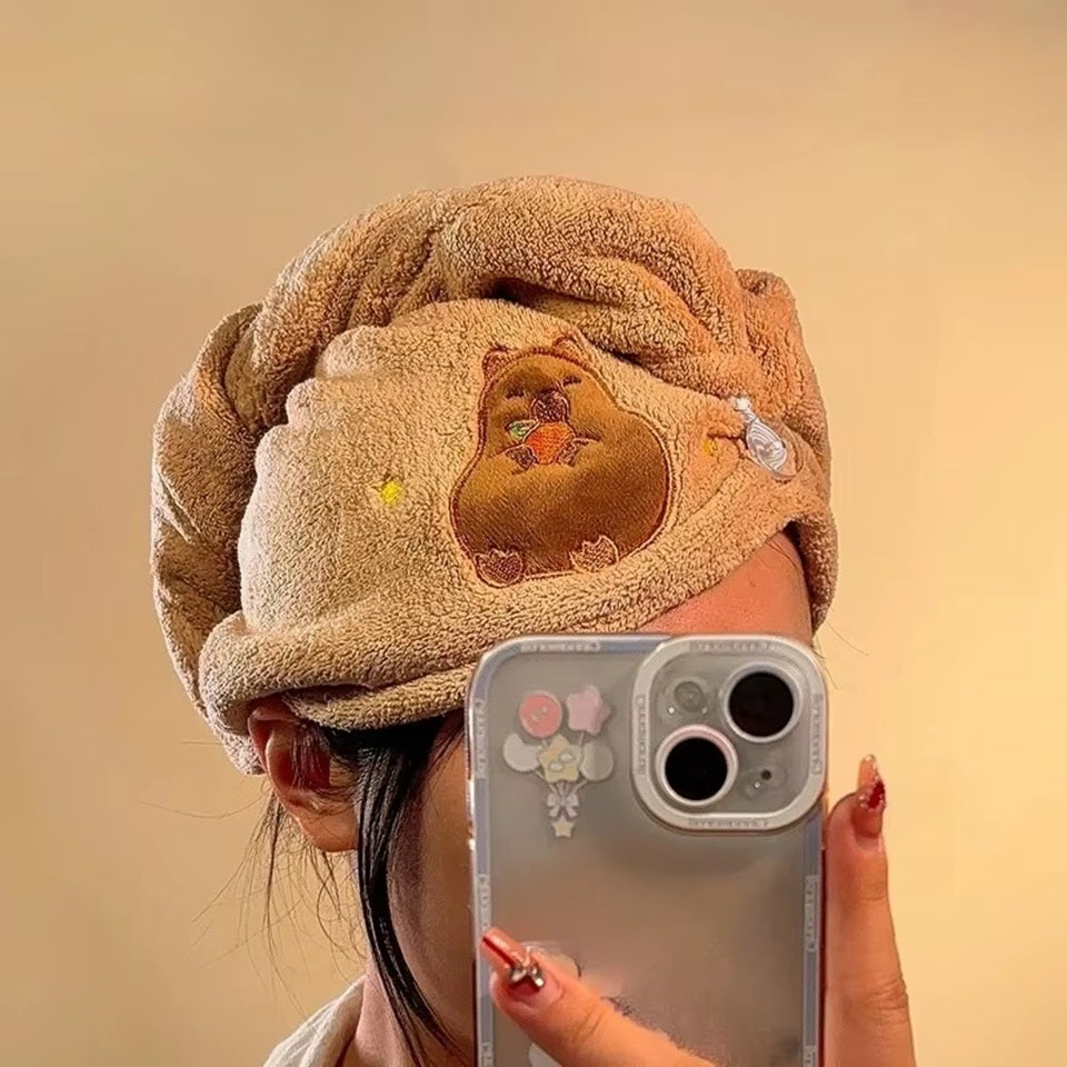 une serviette pour cheveux capybara toute mignonne. Avec son capybara brodé et son sourire charmeur, elle est utile et pratique pour maintenir et sécher les cheveux après la douche ou le bain.