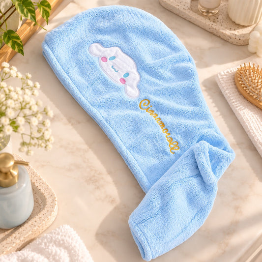 Serviette pour cheveux Cinnamoroll bleu clair en tissu doux, posée à plat dans un joli décor de salle de bain lumineux avec accessoires de soin et fleurs.