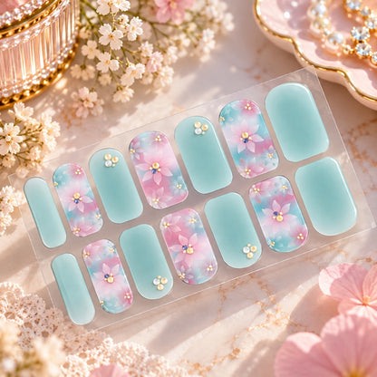 Stickers nail artvert d'eau et rose pastel à motifs fleuris, ornés de petits strass dorés et brillants, présentés dans un élégant décor beauté floral.