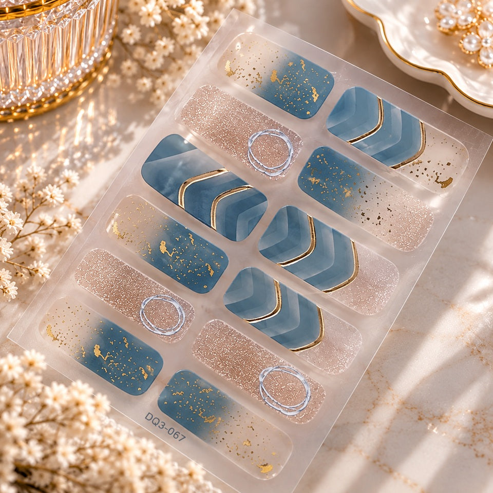 Stickers nail art légèrement transparents bleu canard et rose pailleté, décorés de détails dorés et argentés, présentés dans un élégant décor beauté.