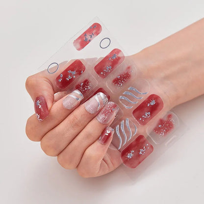 Stickers nail art rose foncé à paillettes avec éclats argentés et motifs ondulés, présentés dans une main de femme qui portent ses stickers aux ongles.