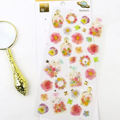 Une jolie planche de stickers en forme de bouteilles de parfum colorées et fleuries. Dans les tons roses, jaunes, bleus et verts, on dirait un jardin parfumé.