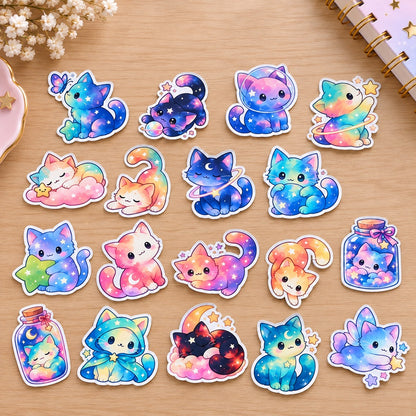 Lot de stickers chats galaxie kawaii aux couleurs pastel, avec étoiles, lunes, planètes et motifs célestes, disposés sur un bureau en bois clair.