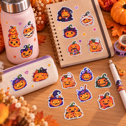 Stickers citrouilles kawaii Halloween orange et violet, collés sur un carnet, une gourde et une trousse, avec plusieurs modèles disposés sur un bureau en bois.