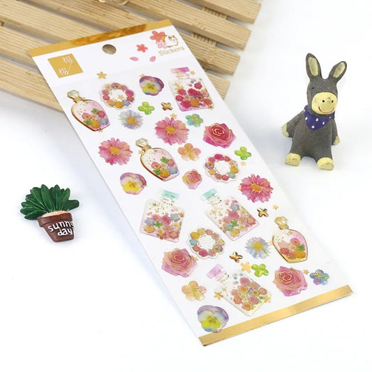 Une jolie planche de stickers en forme de bouteilles de parfum colorées et fleuries. Dans les tons roses, jaunes, bleus et verts, on dirait un jardin parfumé.