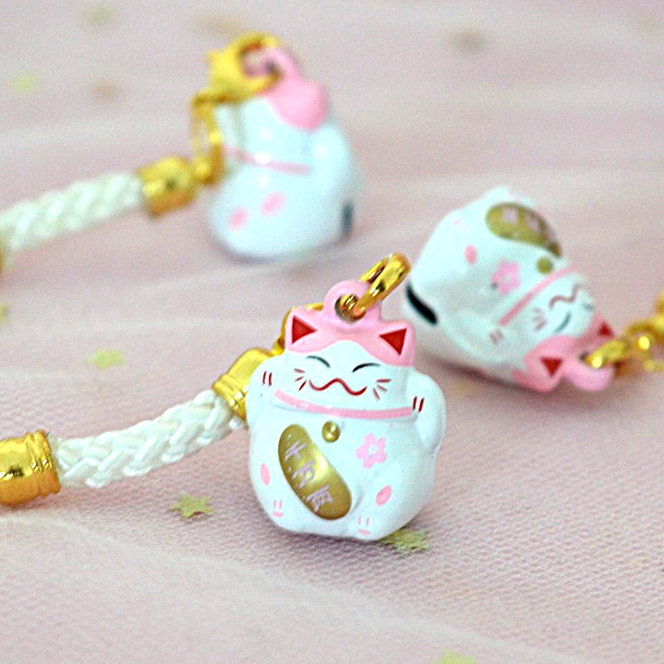 des porte-clés en forme de maneki neko sous forme de grelot. Il y a plusieurs couleurs et designs différents. 