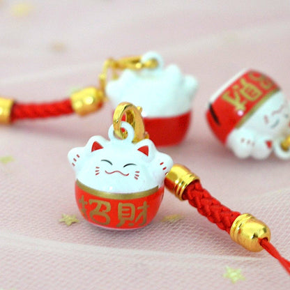 des porte-clés en forme de maneki neko sous forme de grelot. Il y a plusieurs couleurs et designs différents. 