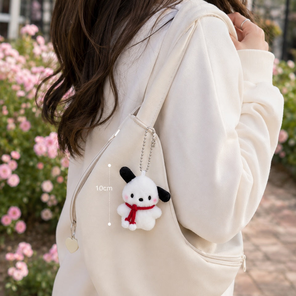 un adorable porte-clé tout en peluche et en douceur en forme d'un chien blanc aux longues oreilles noires qui porte une écharpe rouge.