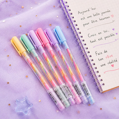 Stylos rainbow kawaii aux couleurs pastel posés sur un tissu violet étoilé à côté d’un carnet rempli de messages positifs ✨ Stylos gel multicolores jaune, vert, rose, violet et bleu avec design transparent inspiré de la papeterie japonaise. Ambiance douce, rêveuse et créative parfaite pour écrire, dessiner ou décorer son journal.