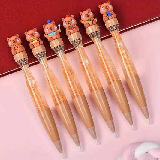 des stylos capybara super mignons et originaux : sur le dessus du stylo se trouve un capybara que l'on peut tourner à l'infini. A l'intérieur du stylo, il y a des paillettes que l'on peut secouer pour un effet amusant