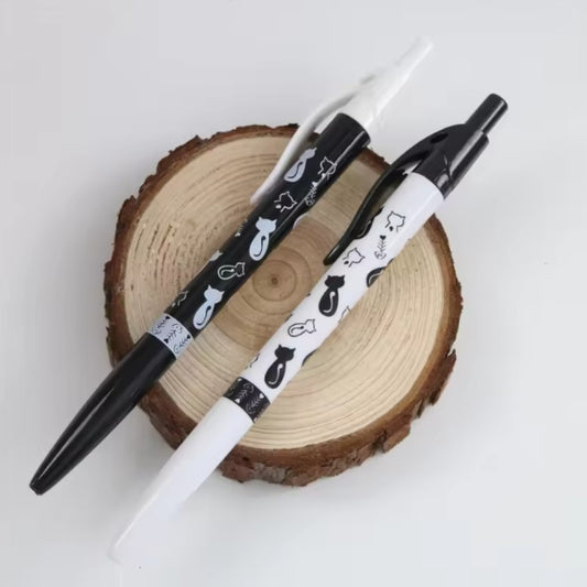un stylo noir ou blanc orné de motif de chat noir et de chat blanc ainsi que d'arêtes de poisson. Le design est original et très mignon. 