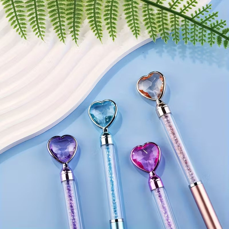 des stylos coeurs colorés dont le corps transparent renferme des strass brillants. Au but du stylo se trouve un joli coeur coloré comme s'il avait été taillé dans un diamant. L'ensemble est poétique et élégant.