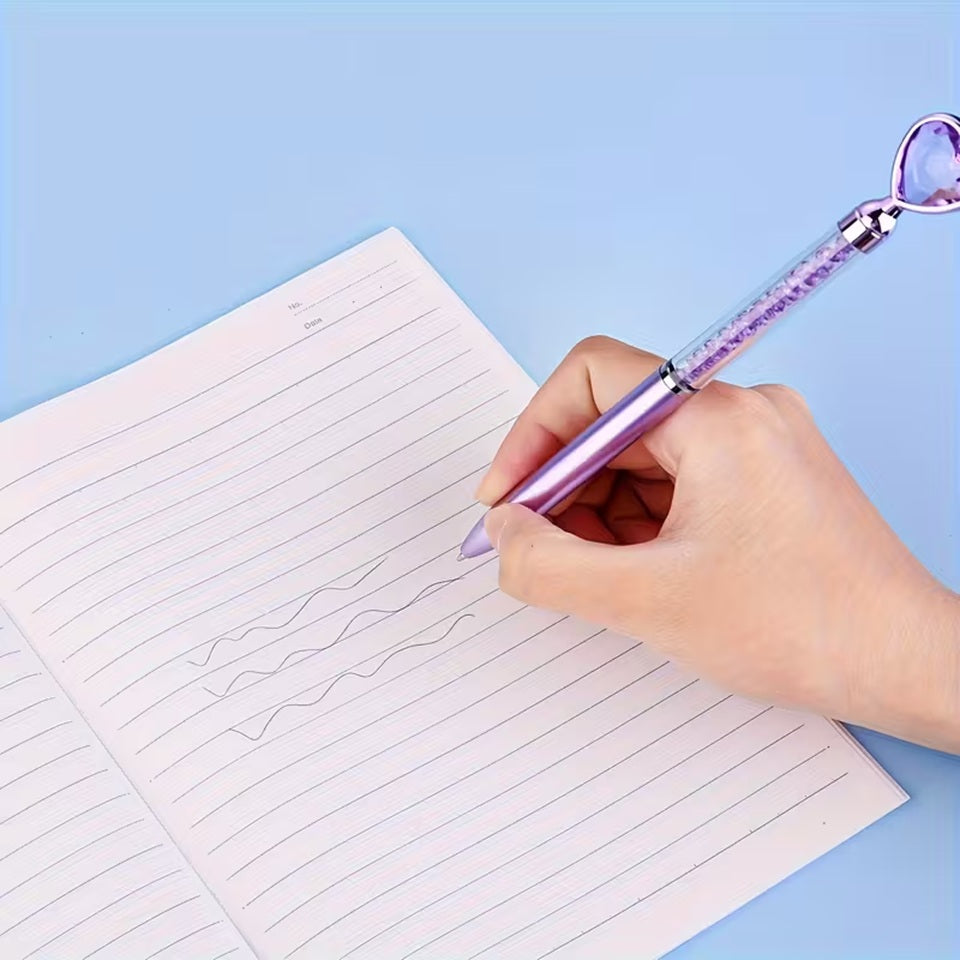 des stylos coeurs colorés dont le corps transparent renferme des strass brillants. Au but du stylo se trouve un joli coeur coloré comme s'il avait été taillé dans un diamant. L'ensemble est poétique et élégant.