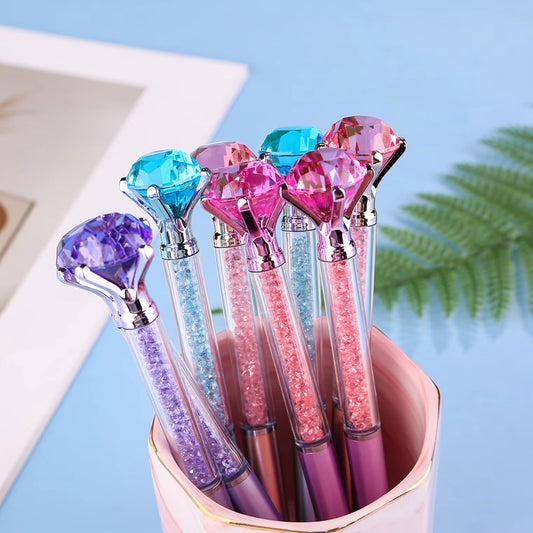 de jolis stylos colorés dont le corps est transparent et renferme des strass colorés. Au bout du stylo, il y a un gros diamant coloré.