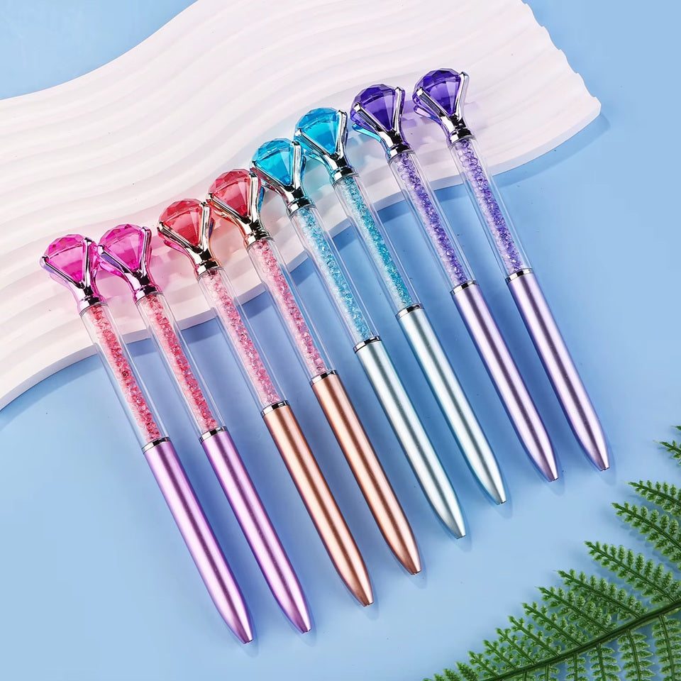 de jolis stylos colorés dont le corps est transparent et renferme des strass colorés. Au bout du stylo, il y a un gros diamant coloré.