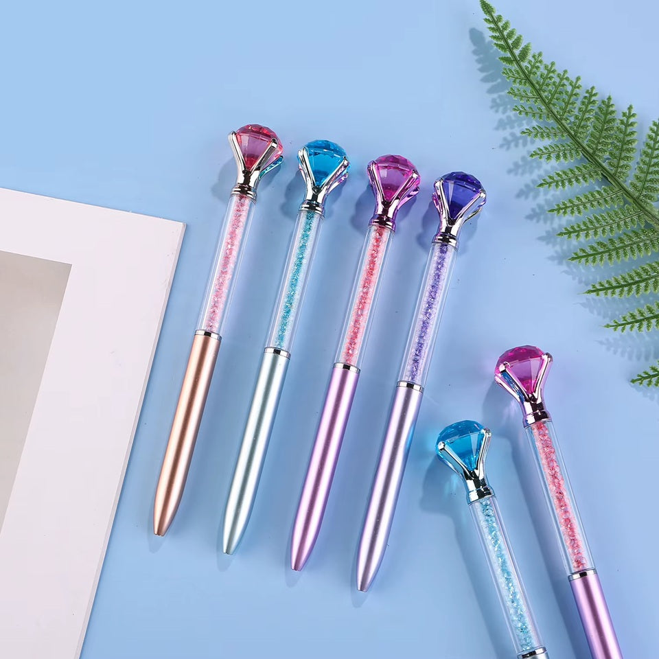 de jolis stylos colorés dont le corps est transparent et renferme des strass colorés. Au bout du stylo, il y a un gros diamant coloré.