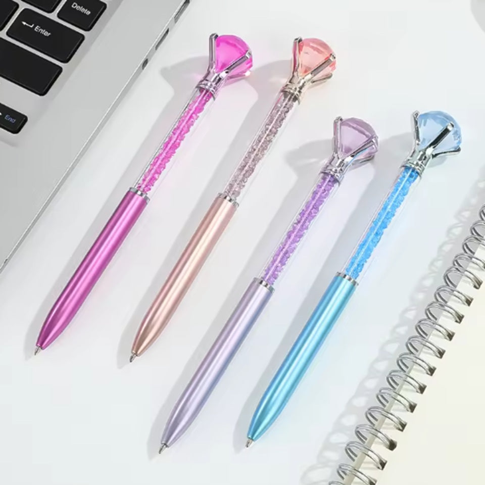 de jolis stylos colorés dont le corps est transparent et renferme des strass colorés. Au bout du stylo, il y a un gros diamant coloré.