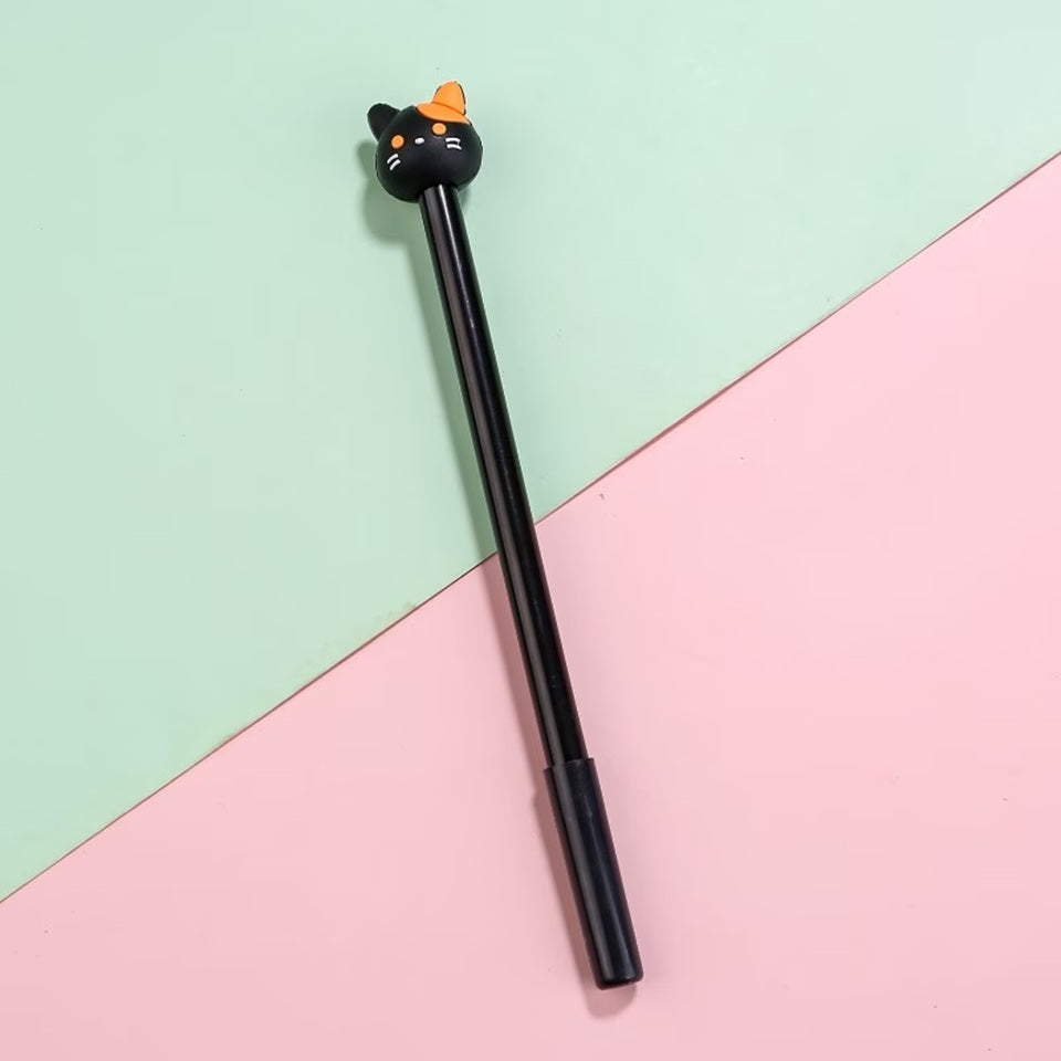 Un stylo noir dont le bout est une tête de chat noir et orange présenté sur un fond bicolore vert et rose pastel. Design mignon et fun.