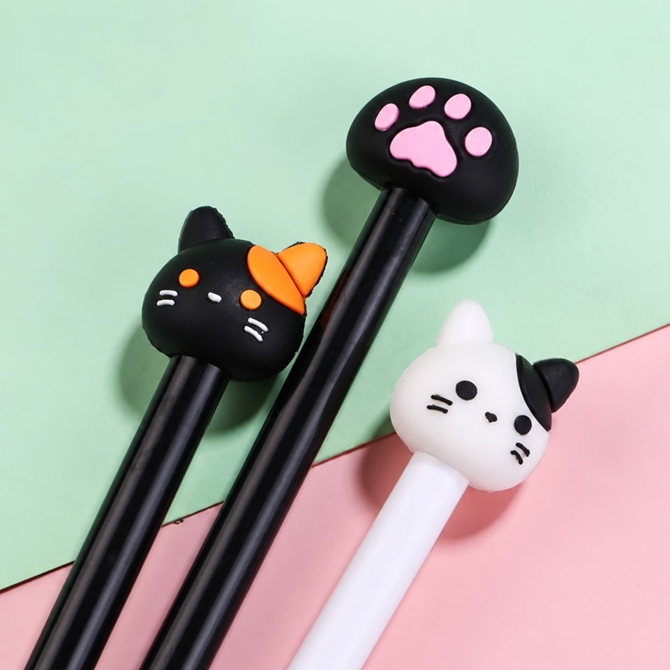 Trois stylos kawaii sur le thème des chats, présentés côte à côte sur un fond pastel vert menthe et rose. Ces adorables stylos fantaisie possèdent des embouts originaux : une tête de chat noir aux détails orange, une tête de chat blanc aux petites oreilles noires et une patte de chat noire aux coussinets roses. Leur design mignon et amusant apporte une touche de douceur à la papeterie kawaii. Parfaits pour égayer une trousse, décorer un bureau ou offrir un joli cadeau aux amoureux des chats et des accessoir