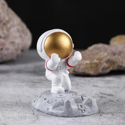 un support pour smartphone en forme d'un astronaute tout mignon. Posez votre smartphone sur ses mains, l'astronaute est en position pour le retenir afin qu'il ne tombe pas. Elément de déco sympa et adorable