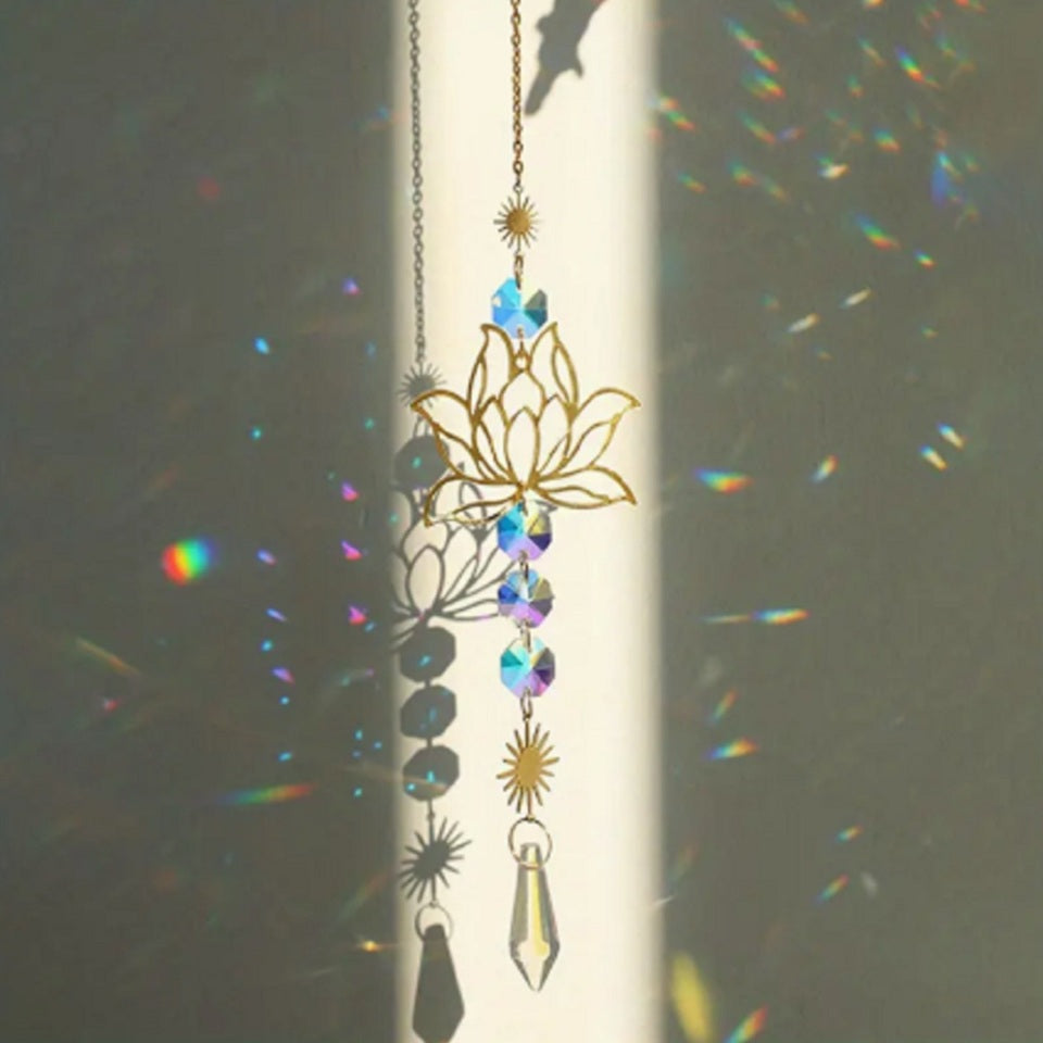 une superbe décoration à suspendre composée d'une fleur de lotus, de soleils métalliques ouvragés et de strass scintillants. L'ensemble est poétique et romantique et reflètent la lumière pour créer de magnifiques effets scintillants.