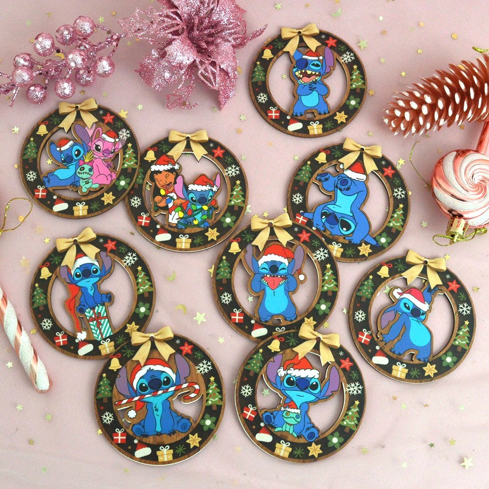 des décorations en bois à suspendre dans le sapin inspirés par Lilo, Stitch et Angel. Décorés de motifs de Noël (sapin, cadeaux, flocons etc..) ils représentent Stitch portant un bonnet de Noël rouge.