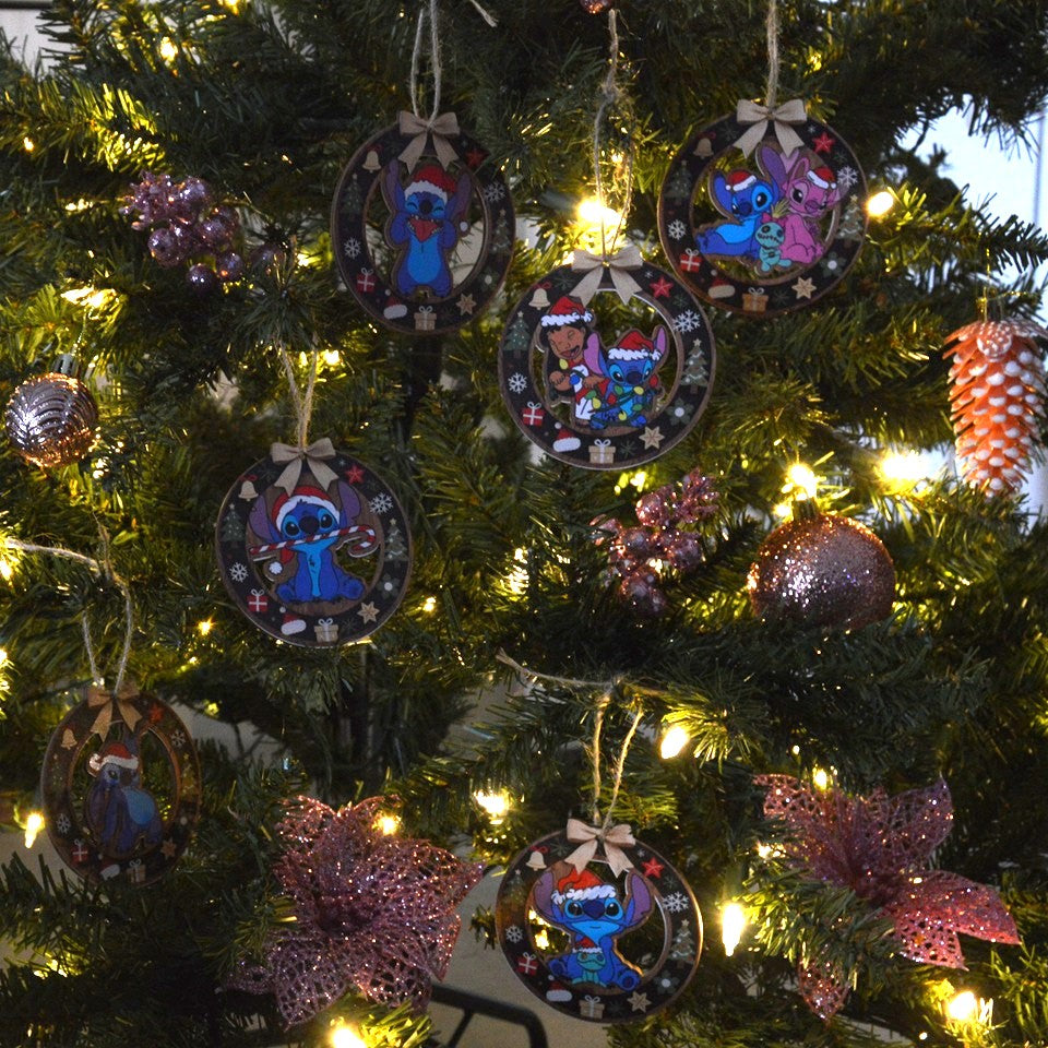 des décorations en bois à suspendre dans le sapin inspirés par Lilo, Stitch et Angel. Décorés de motifs de Noël (sapin, cadeaux, flocons etc..) ils représentent Stitch portant un bonnet de Noël rouge.
