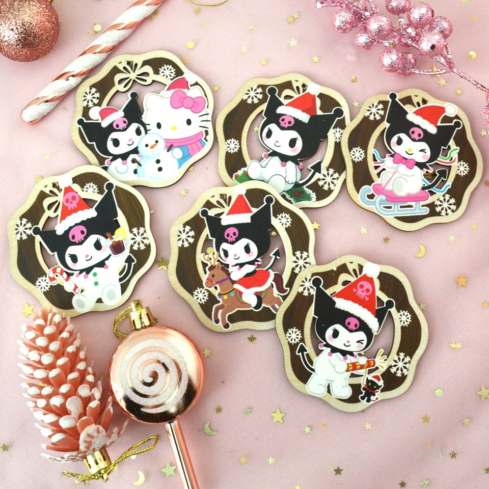 des décorations en bois à suspendre dans le sapin version Kuromi de Noël. Représentée dans différentes scènes adorables, kuromi porte un bonnet de Noël rouge.