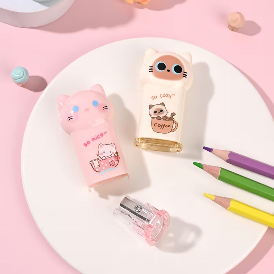 des taille-crayons adorables en forme de chat coloré : noir, rose et beige. Ils ont une expression kawaii trop mignonne. Ils ont une petite illustration sur le devant : un chat dans une tasse