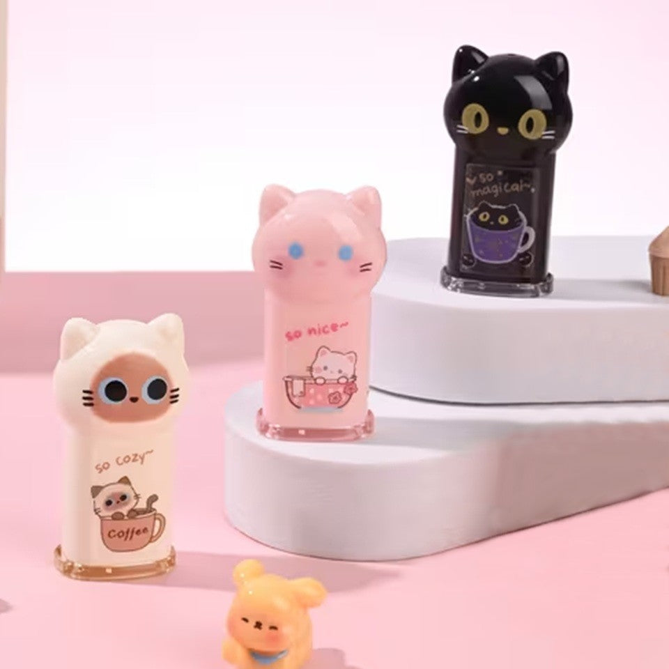 des taille-crayons adorables en forme de chat coloré : noir, rose et beige. Ils ont une expression kawaii trop mignonne. Ils ont une petite illustration sur le devant : un chat dans une tasse